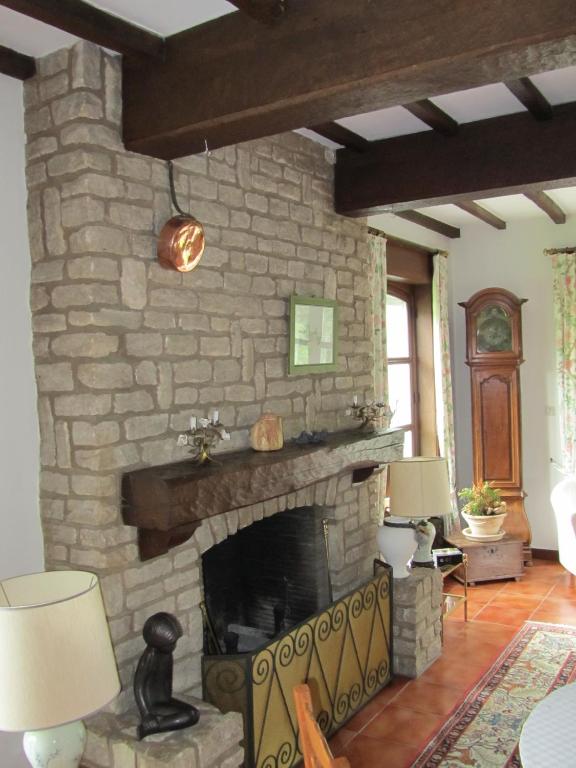 a stone fireplace in a living room with two lamps at B&B El Tyu in Écaussinnes-dʼEnghien