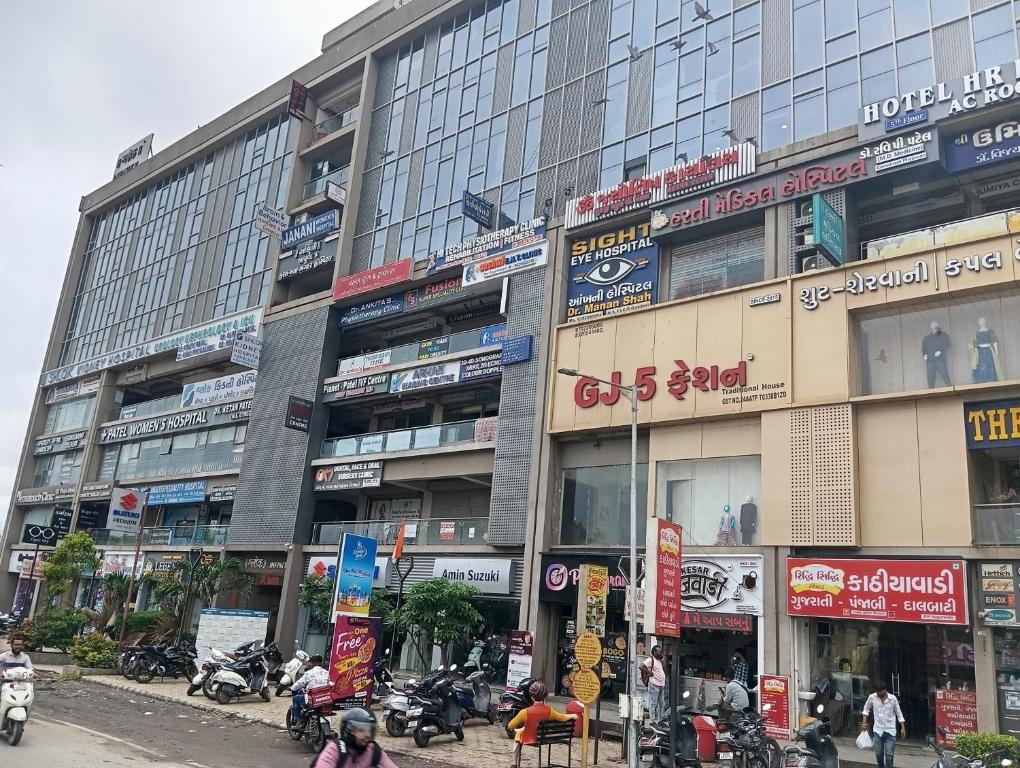 a large building with motorcycles parked in front of it at Hotel HR fortune gota in Ahmedabad