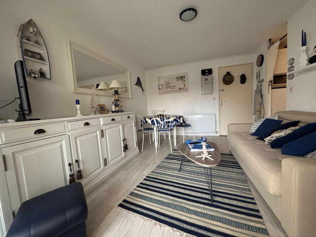 un salon avec un canapé et une table dans l'établissement Appartement 2 pièces à Royan/Pontaillac avec balcon et parking - FR-1-494-203, à Royan