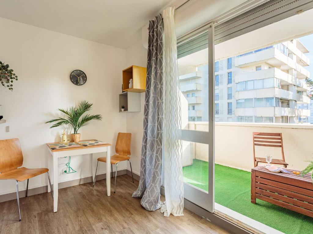 une pièce avec un bureau et une grande fenêtre dans l'établissement Studio moderne avec balcon et parking à Biarritz - FR-1-3-625, à Biarritz