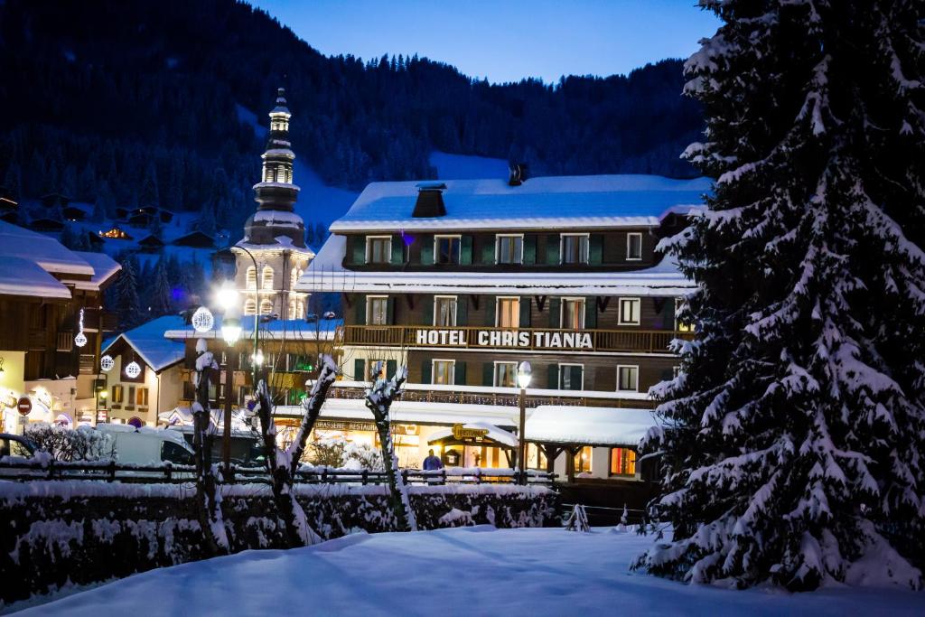 un hotel en la nieve frente a un edificio en Hotel Christiania en La Clusaz