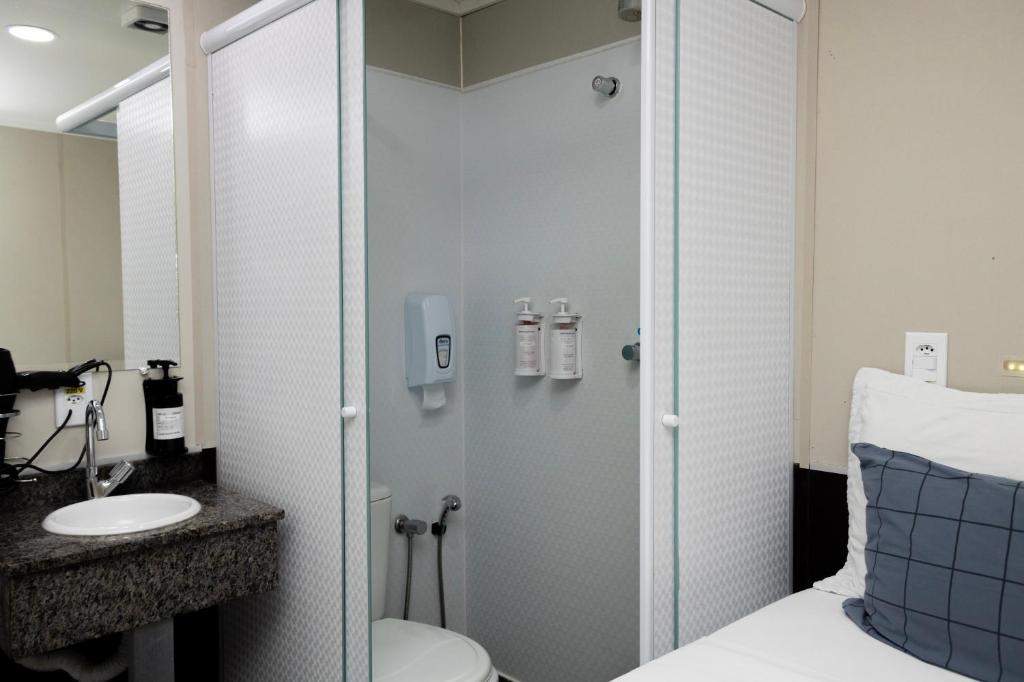 a bathroom with a shower and a toilet and a sink at Hotel Aero Sleep Campinas in Campinas