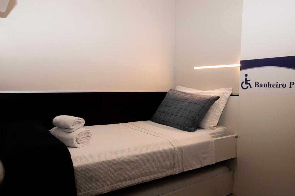 a small bedroom with a bed with a black headboard at Hotel Aero Sleep Campinas in Campinas
