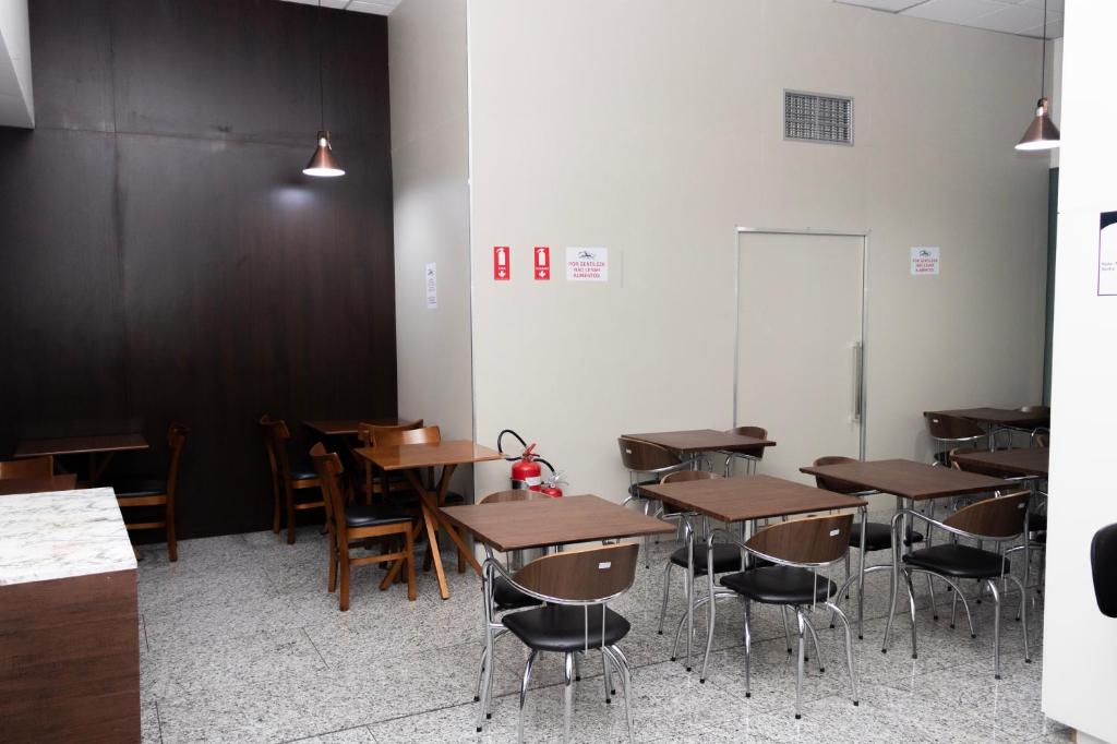 a classroom with tables and chairs and a chalkboard at Hotel Aero Sleep Campinas in Campinas
