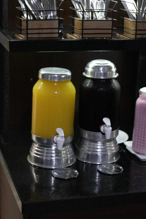 two jars of juice on a counter with coins at Hotel Aero Sleep Campinas in Campinas