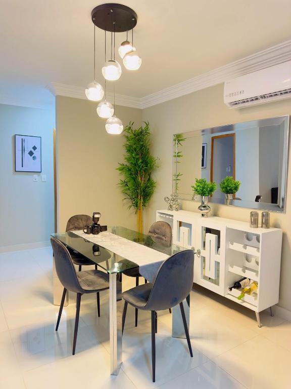 Un comedor con una mesa de cristal y sillas. en Excelente Apartamento Completo Renta Carro Disponible, en La Viva