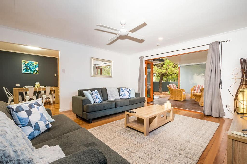 a living room with a couch and a ceiling fan at Driftwood By Khove in Gold Coast