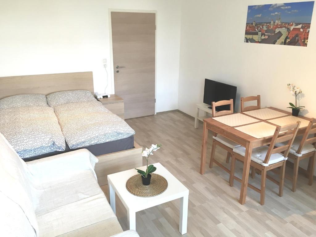 ein Wohnzimmer mit einem Bett und einem Esstisch in der Unterkunft Apartment Newstyle in Regensburg