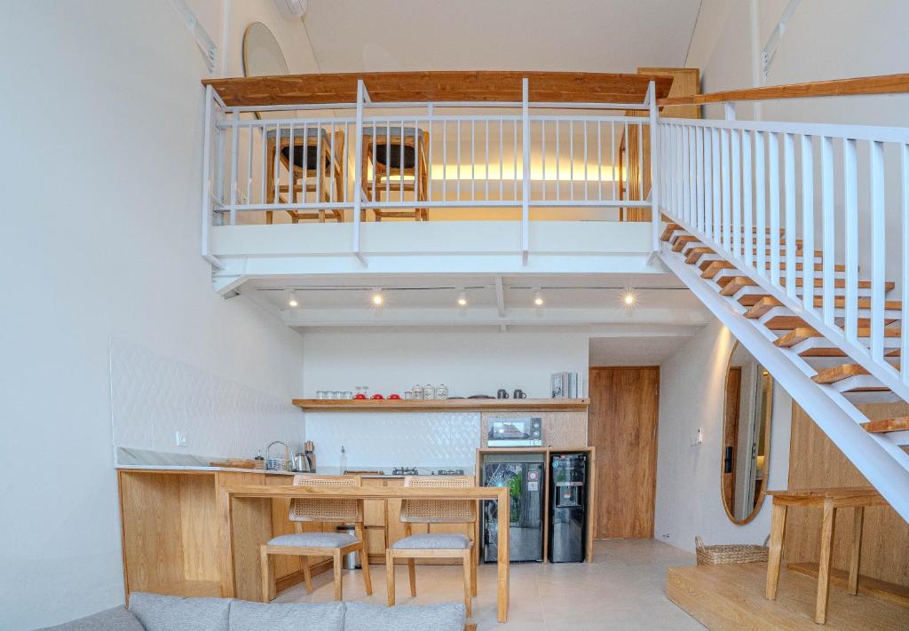a kitchen with a wooden table and a staircase at Jiva Loft Style Villa in Canggu