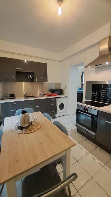 une cuisine avec une table en bois et des chaises. dans l'établissement Logement entier 2-3 p, à Paris