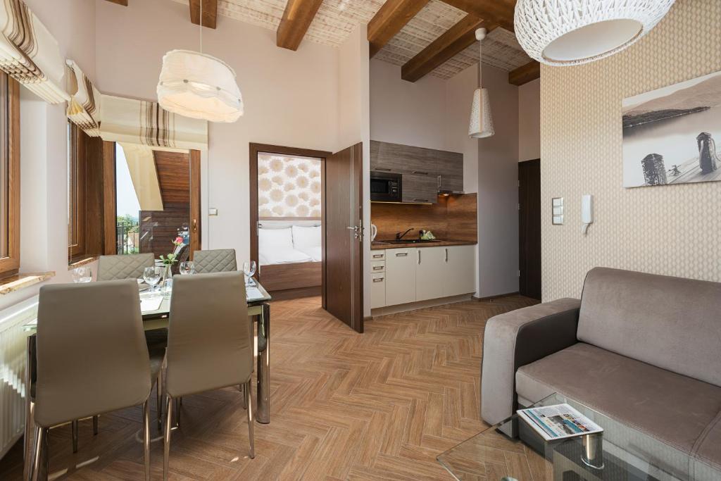 a living room with a dining table and a kitchen at Apartamenty Willa Ada in Jastarnia