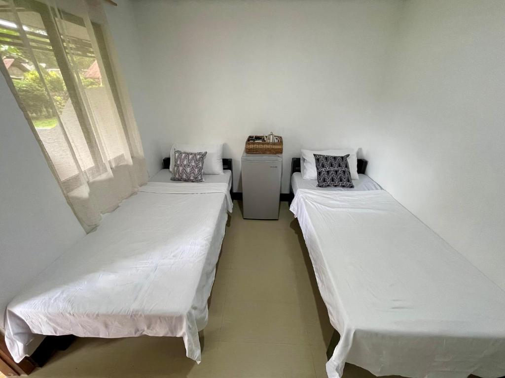 Postel nebo postele na pokoji v ubytování Nayon Inn