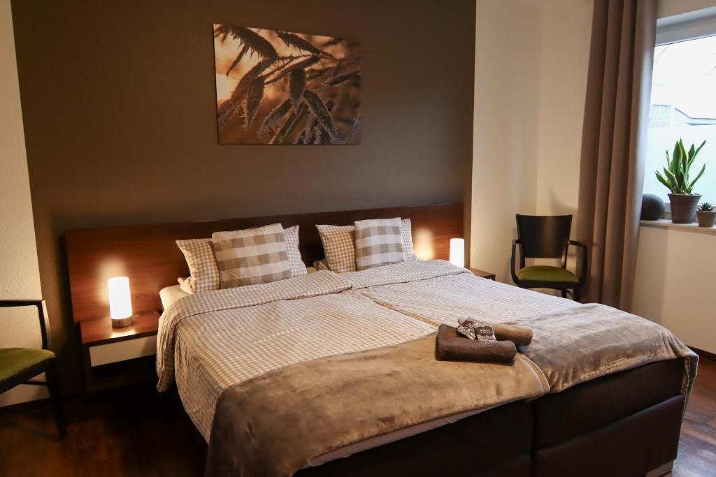 a bedroom with a large bed with pillows and a purse on it at Pension Dalinghaus in Vörden