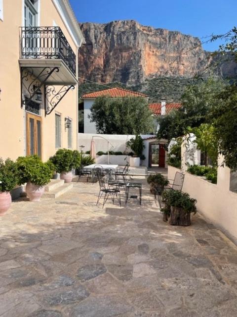 a patio with tables and chairs in front of a mountain at 1867 Manor in Leonidio
