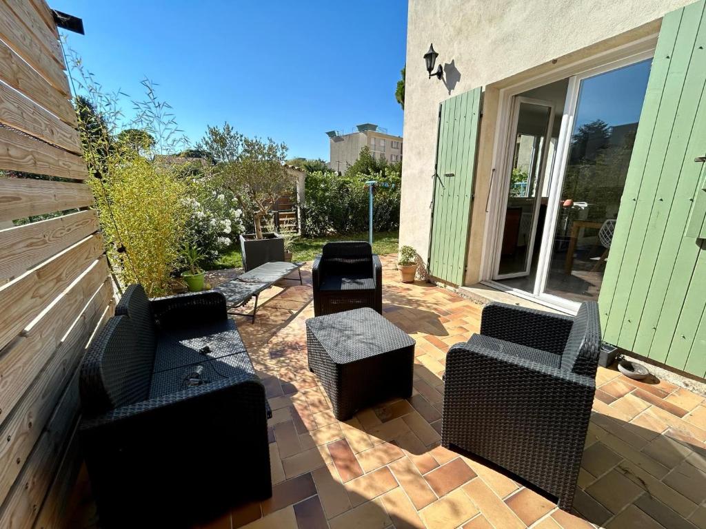un patio avec un groupe de chaises et un bâtiment dans l'établissement Bel appartement de quartier, terrasse et jardin, à Montélimar