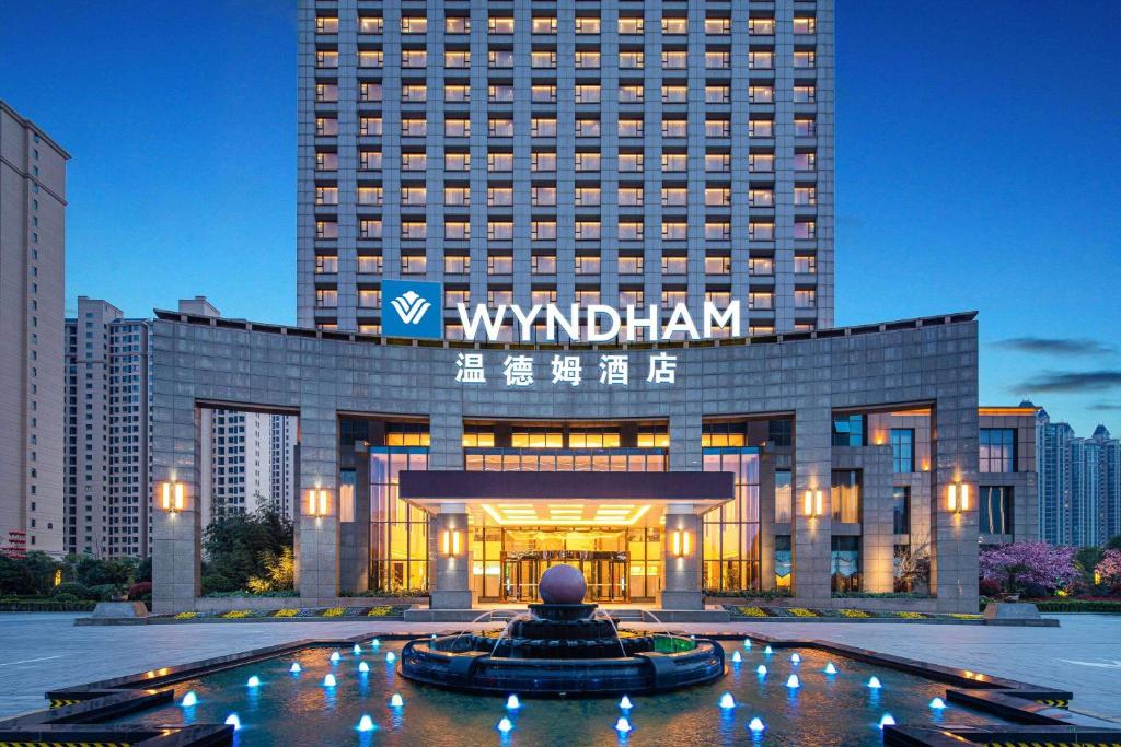 a large building with a sign in front of it at Wyndham Xinyang Downtown in Xinyang