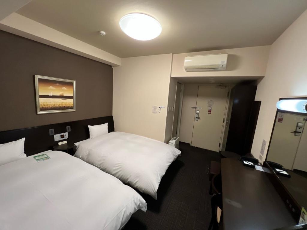 Postel nebo postele na pokoji v ubytování Hotel Route-Inn Uozu