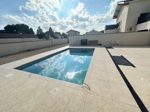 une piscine au milieu d'une maison dans l'établissement Maison 90 avec 8 chambres lechaffardcom, à Satolas-et-Bonce