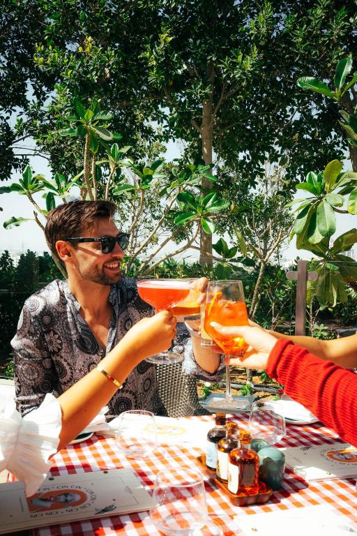 a man and woman sitting at a table with drinks at FIVE Jumeirah Village in Dubai