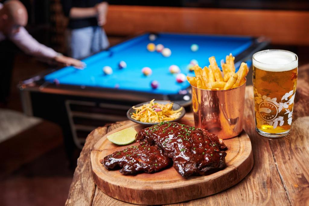 a wooden table with a plate of food and a drink at FIVE Jumeirah Village in Dubai