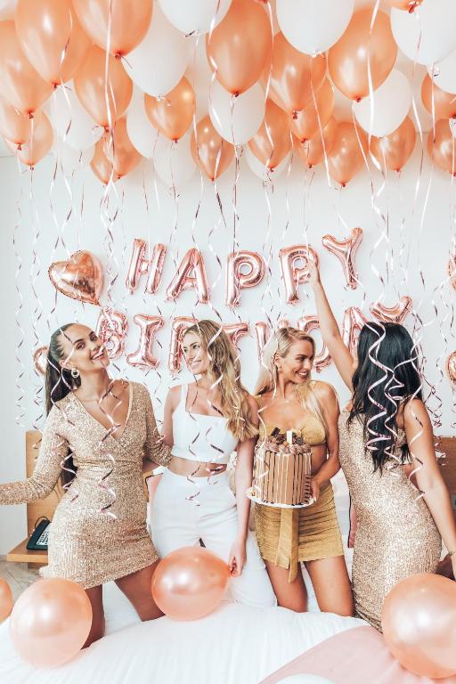 a group of girls standing in front of balloons at FIVE Jumeirah Village in Dubai