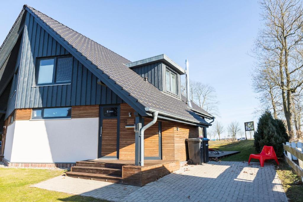 a house with a red chair in front of it at Ferien_HAUS AM AHORNECK _ THEA in Göhren-Lebbin