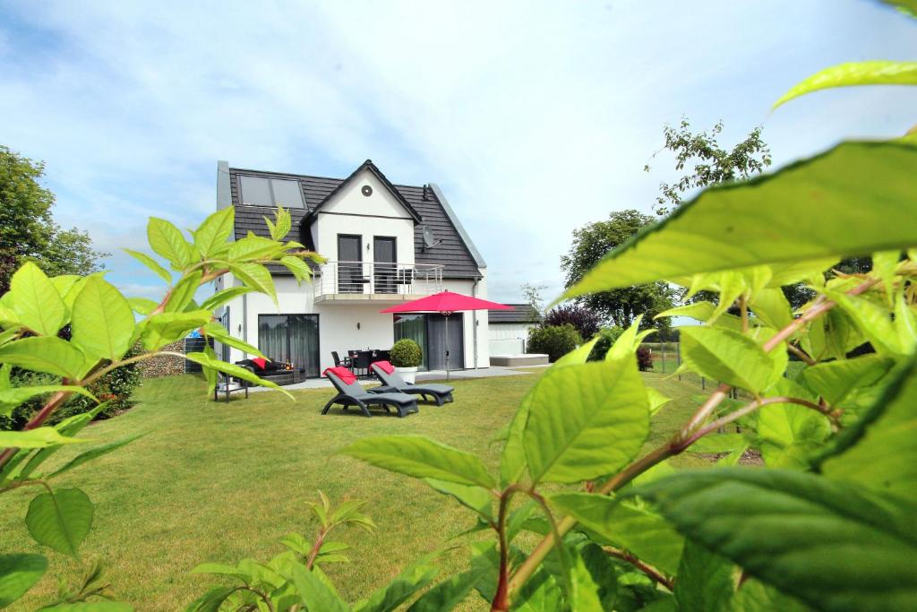 a house with a yard with green plants at Luxus Ferien VILLA VIVALDI in Göhren-Lebbin