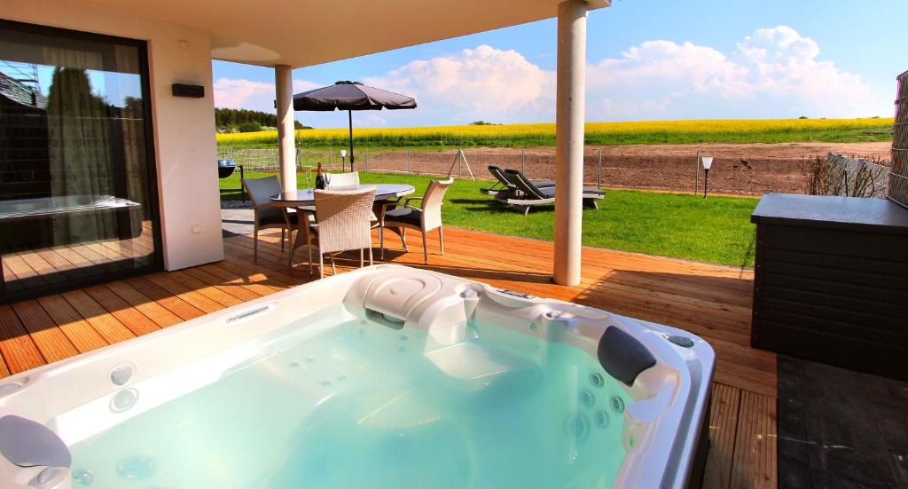 a jacuzzi tub on a deck with a table and a patio at VILLA AQUILA _ EG_Fewo in Göhren-Lebbin