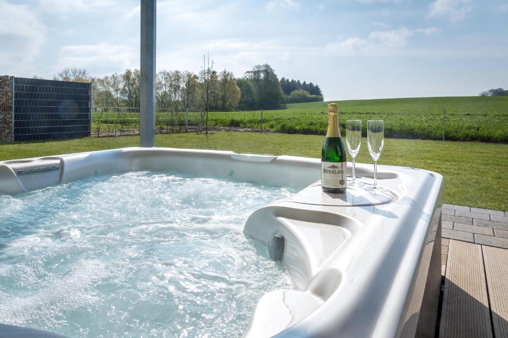 a hot tub with a bottle of champagne and wine glasses at VILLA MON BIJOU _ EG_Fewo in Göhren-Lebbin