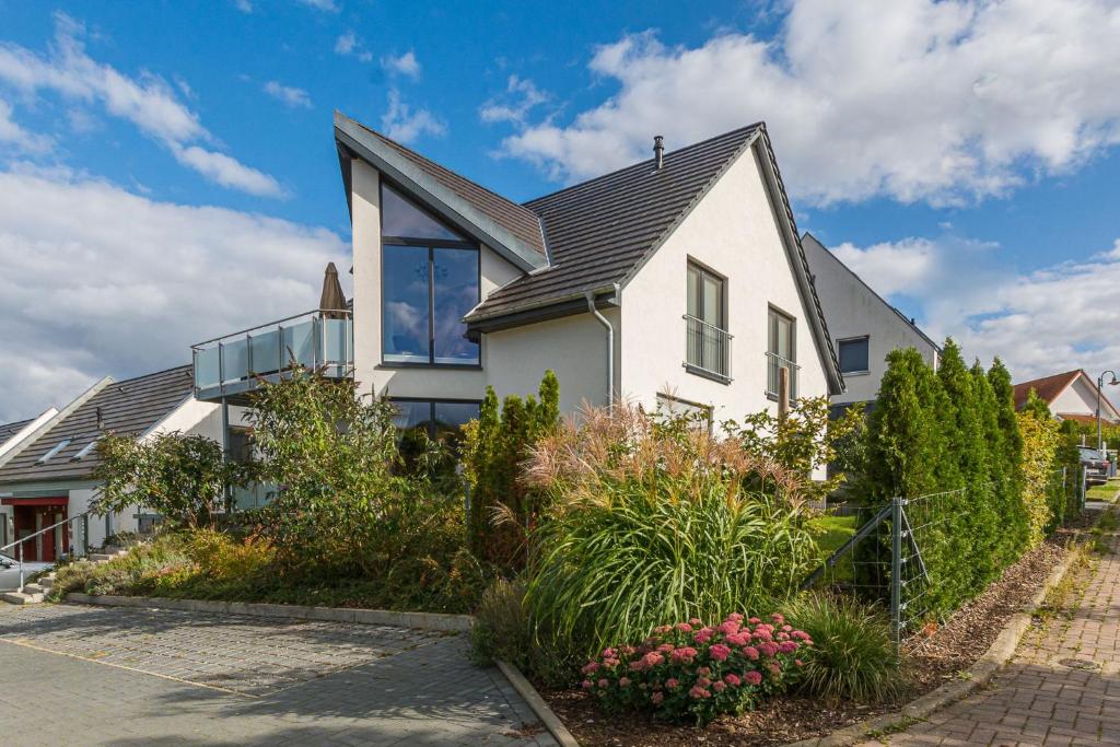 a white house with a black roof at VILLA LIFESTYLE _ HONEYMOON_SUITE in Göhren-Lebbin