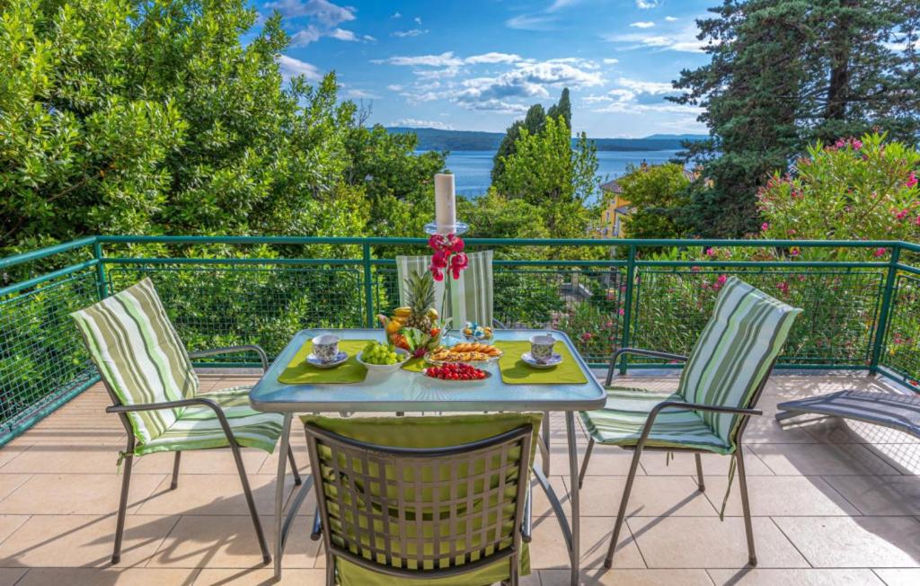 a table with four chairs and a candle on a balcony at Beautiful Villa Ana with sea view in Crikvenica in Crikvenica