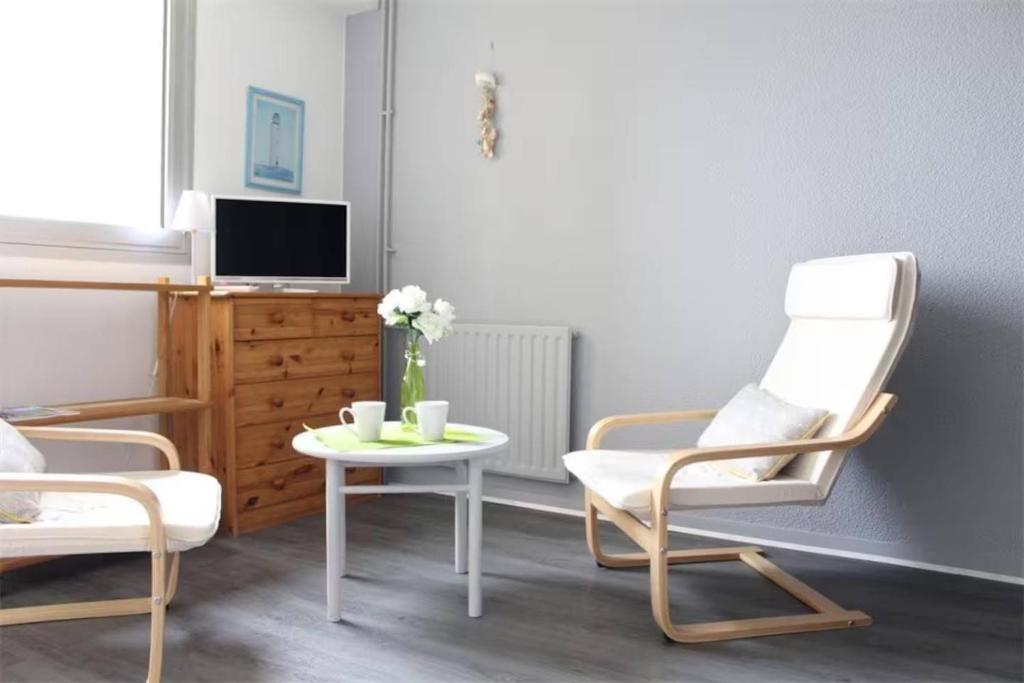un salon avec deux chaises et une table dans l'établissement Appt Studio LA ROCHELLE LR240-402, à La Rochelle