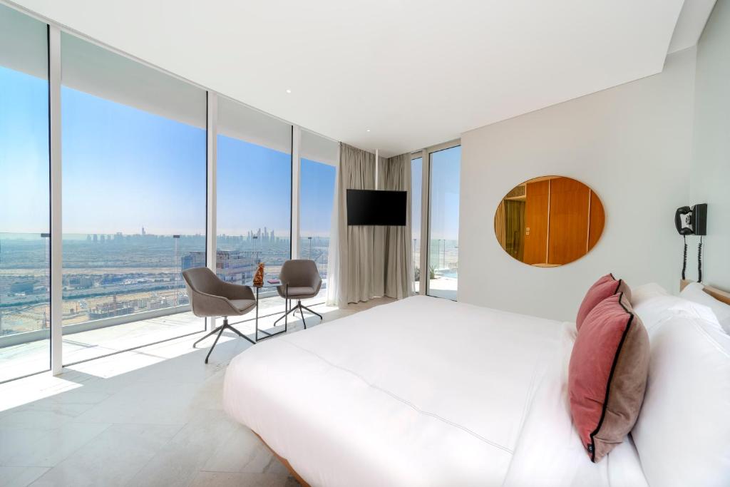 a bedroom with a white bed and a large window at FIVE Jumeirah Village in Dubai