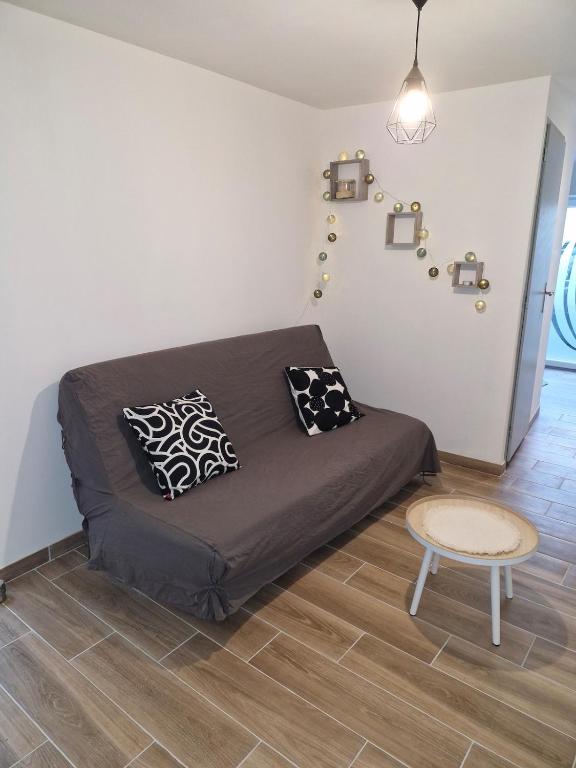 Cette chambre comprend un lit avec des oreillers et une table. dans l'établissement village house, à Villegly