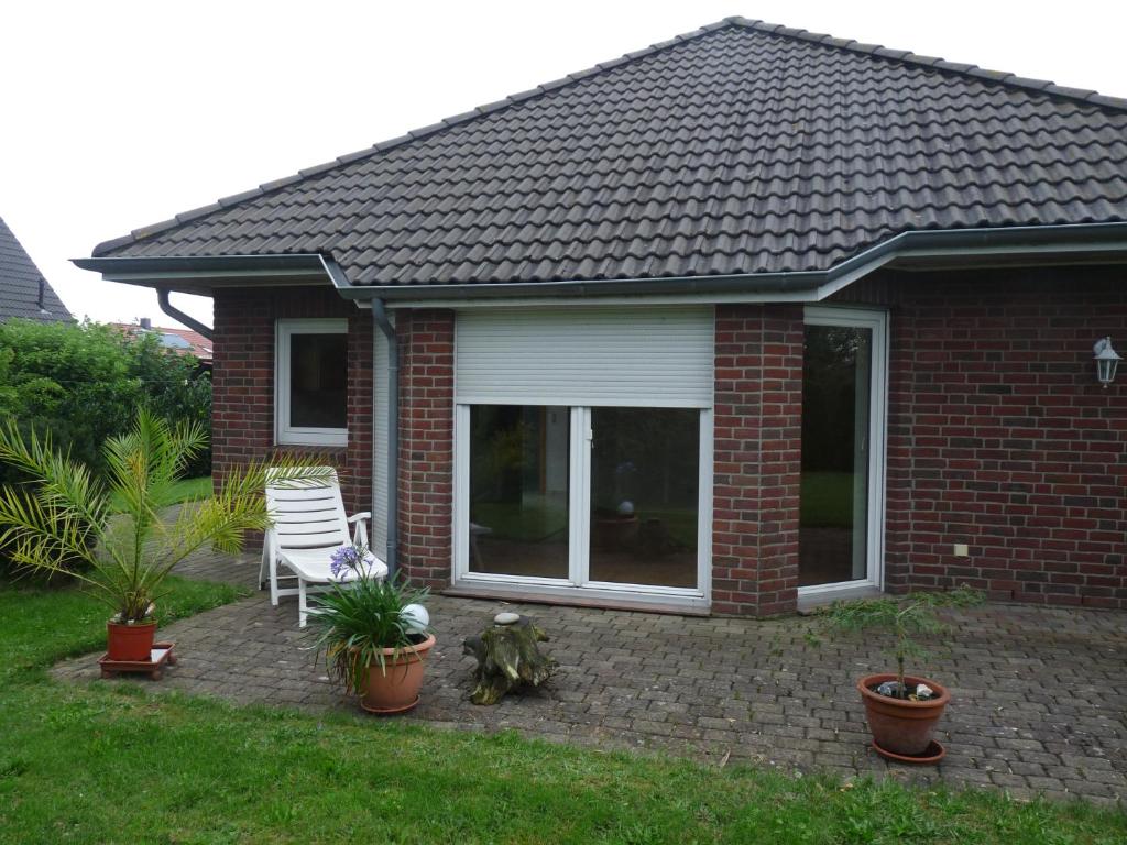 a brick house with a patio with a table and chairs at Ferienwohnung Ahausen in Ahausen