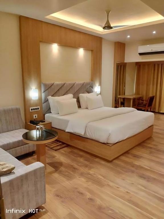 a bedroom with a large bed and a couch at Hotel Relax in Jāmb