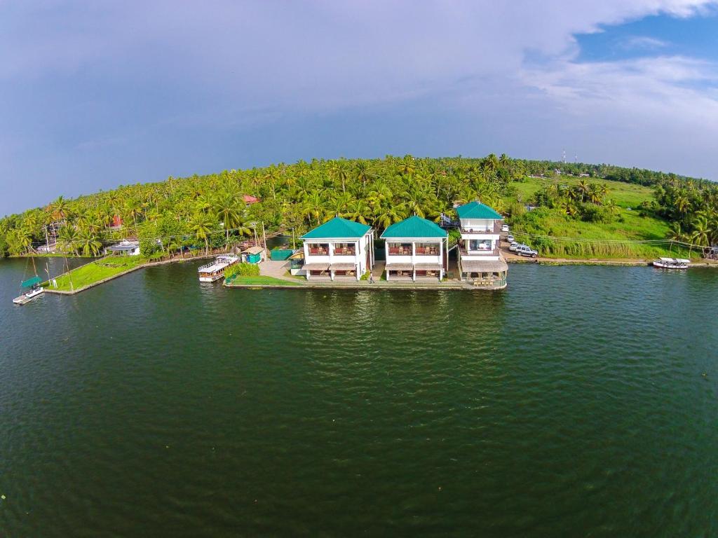 a group of houses on a dock in the water at Mira's PMC Lakeshore Resort in Alleppey