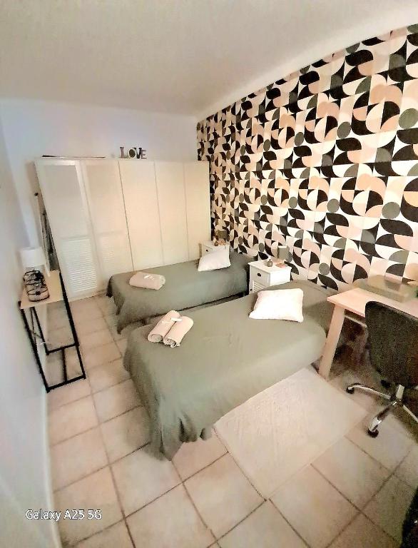 Cette chambre dispose d'un bureau et d'un canapé vert. dans l'établissement Emplacement idéal 450 métres du Palais croisette plage, à Cannes