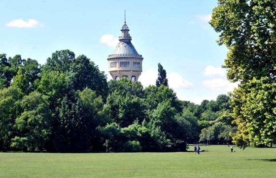 a building in the middle of a field with trees at Louis Apartment in Budapest