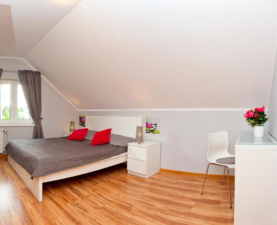 sypialnia z łóżkiem z 2 czerwonymi poduszkami w obiekcie Pokoje Gościnne Pod Brzozą we Władysławowie