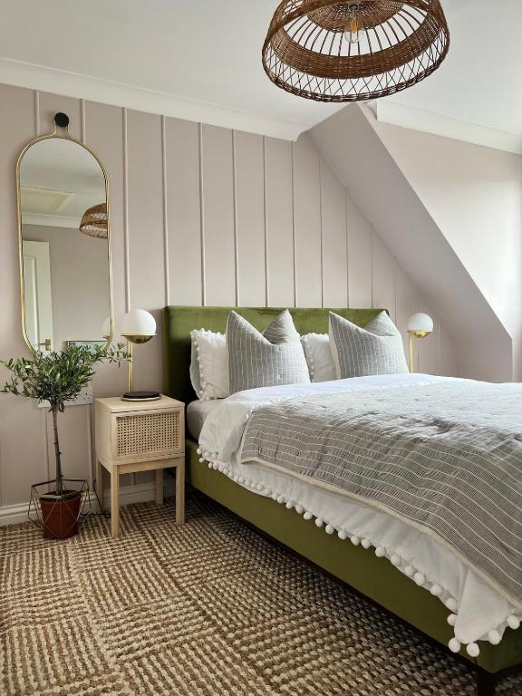 a bedroom with a large bed and a mirror at Luxury coastal retreat - On-site parking - sleeps 4 in Ilfracombe