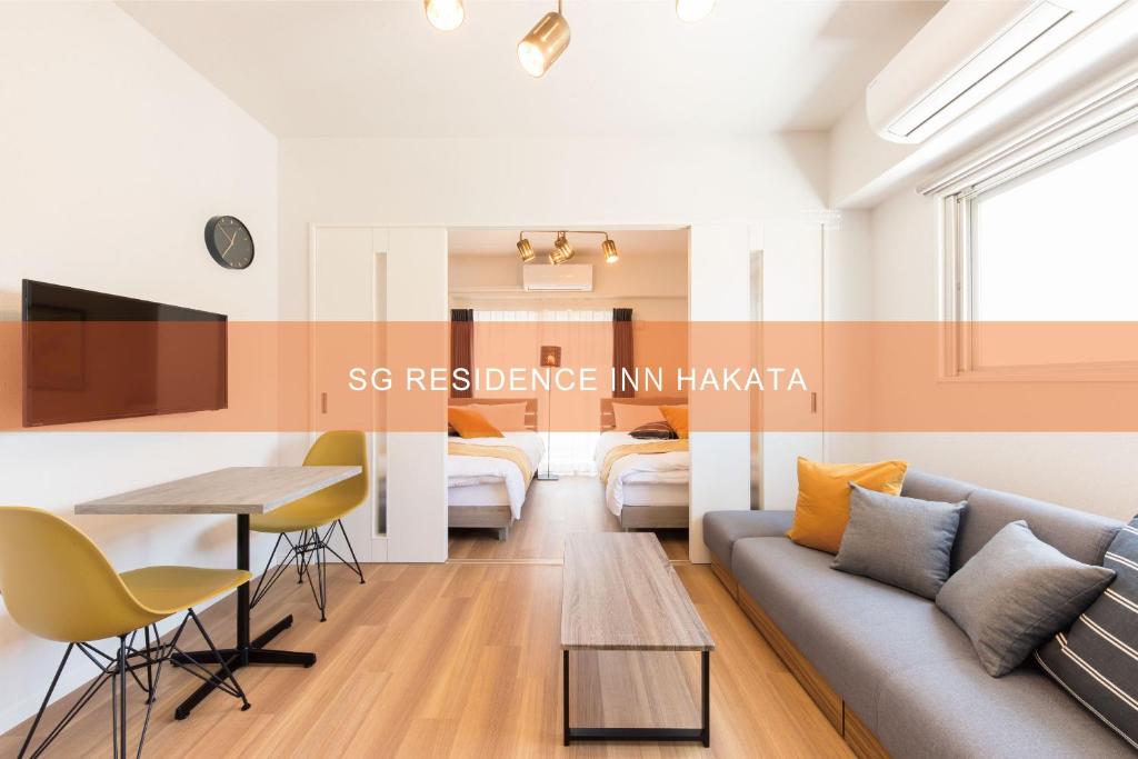 福岡市にあるSG RESIDENCE INN HAKATAのソファとテーブルのあるリビングルーム