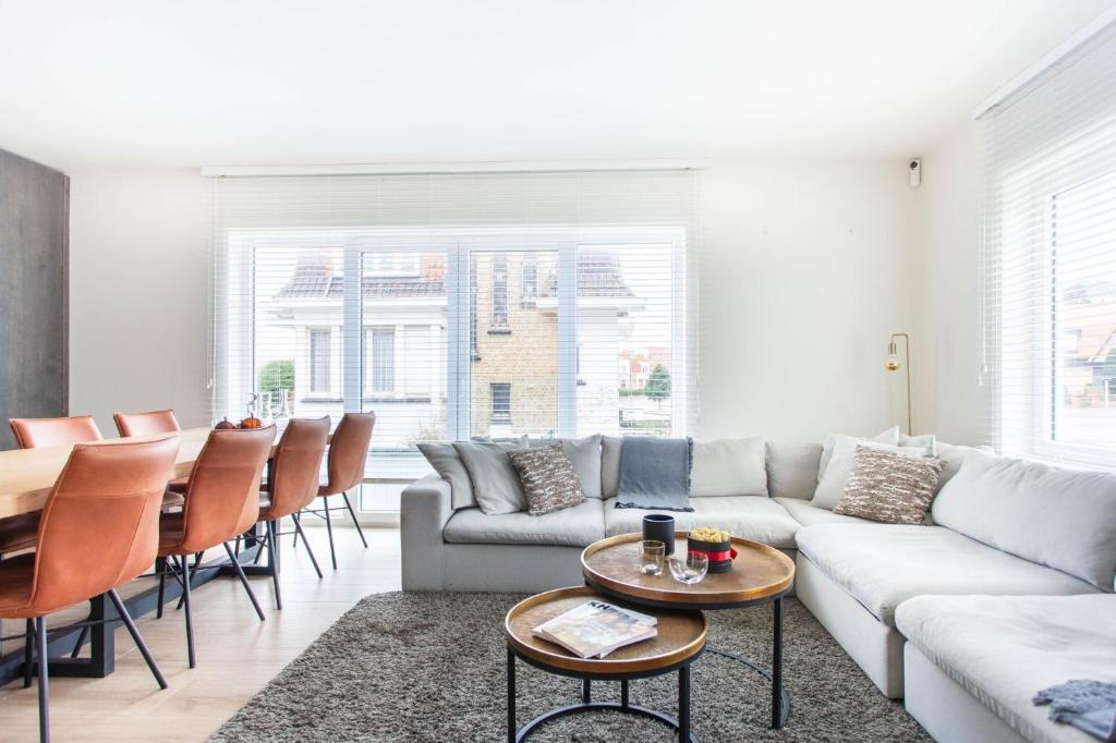 a living room with a couch and a table at Elegant Coastal Retreat in Knokke-Heist in Knokke-Heist