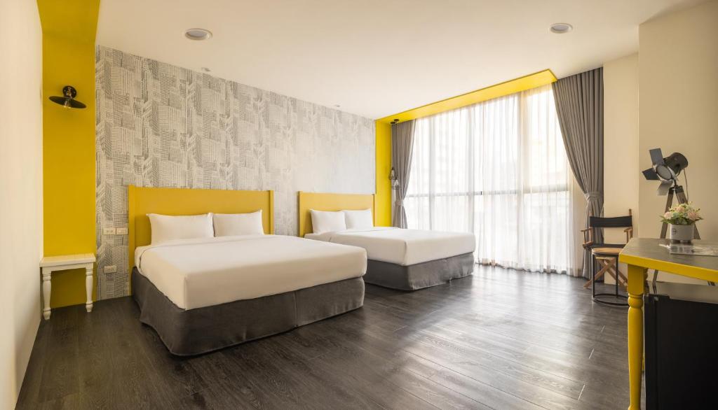 a hotel room with two beds and a window at 凝萃文旅 台中車站店 NCH-Business Hotel in Taichung