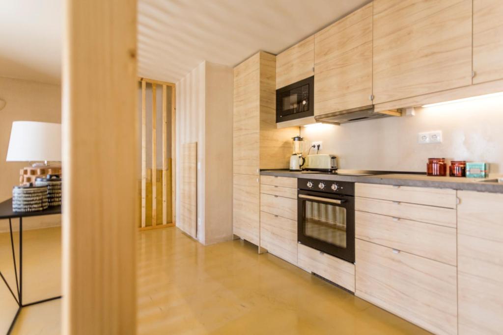 a kitchen with wooden cabinets and a stove at Sea'Ya Thoughtful Stays - Villas in Cascais