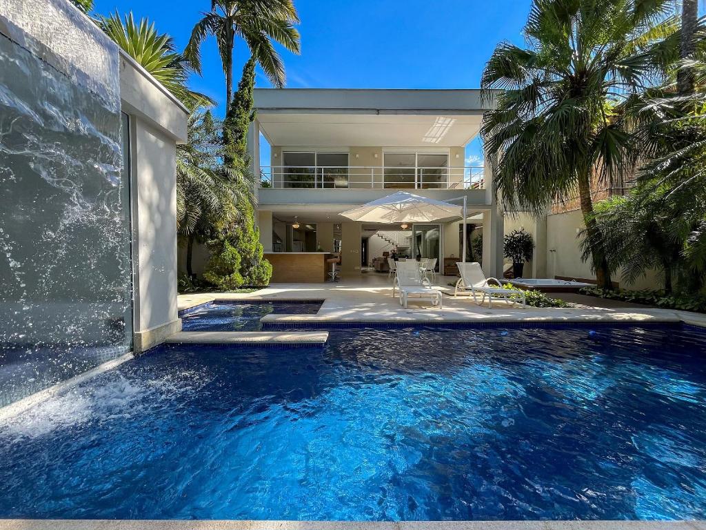 a swimming pool in front of a house at Casa Bella - Deslumbrante c/Enxoval - Riviera Md 5 in Riviera de São Lourenço