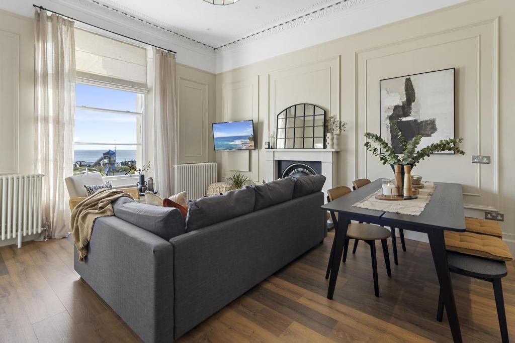 un soggiorno con un divano e un tavolo di Sea Breeze, Luxury Views Seafront Stylish Home a Teignmouth