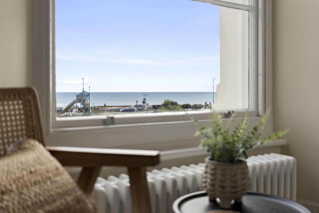 a room with a window with a view of the beach at Sea Breeze, Luxury Views Seafront Stylish Home in Teignmouth