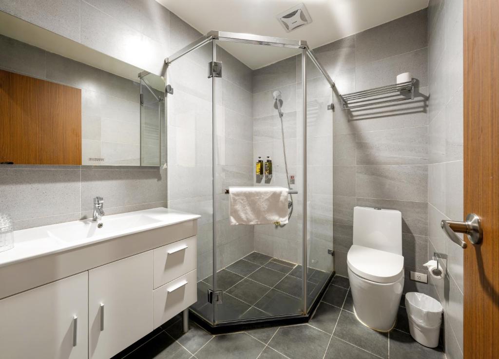 a bathroom with a shower and a toilet and a sink at 凝萃文旅 台中車站店 NCH-Business Hotel in Taichung