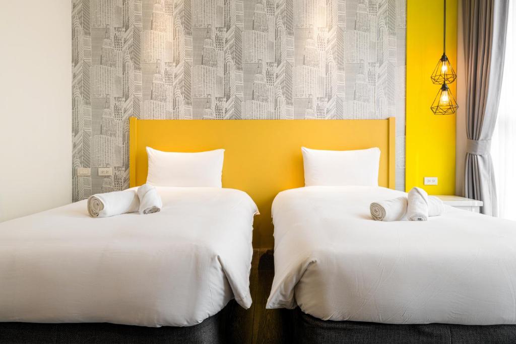 two beds sitting next to each other in a room at 凝萃文旅 台中車站店 NCH-Business Hotel in Taichung